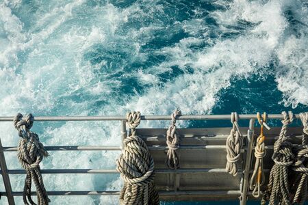 Ropes Tied to Railing over blue watersの写真素材