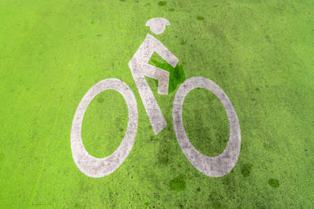 Green Bike Lane Painted on dirty roadの写真素材