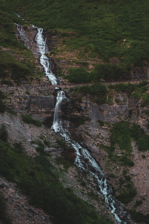 Aster Falls Tumbles Over Cliff and Under Going to the Sun Road in Glacier National Parkの写真素材