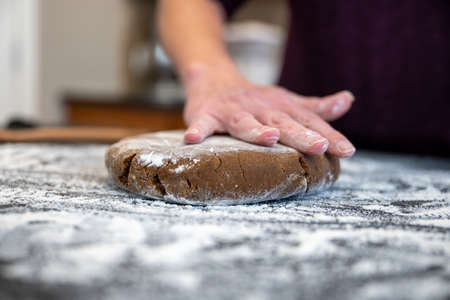 Pressing a Disk of Gingerbread Cookie Dough  Into Floured Surfaceの写真素材