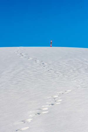 Footsteps Head Up Over Sand Dune to Trail Marker in White Sands National Park