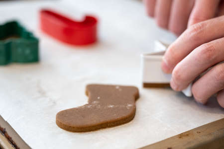 Pressing Gingerbread Cookies onto Parchment Paper during a holiday baking sessionの写真素材