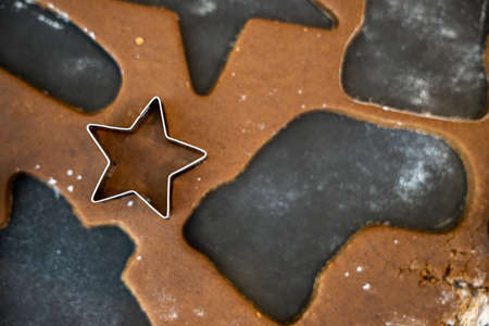 Cutting out a Tiny Star Cookie from a scrap of gingerbread doughの写真素材