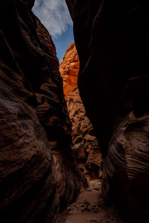 Bright Orange Rocks Pop Out At The End of A Dark Slot Canyon in southern Utah