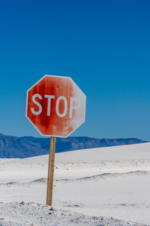 Shifting White Sand Slowly Taking Over Stop Sign in White Sands National Parkの写真素材