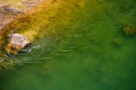 Ripples And Boulder In The Bright Green Colorado River in the Grand Canyonの写真素材