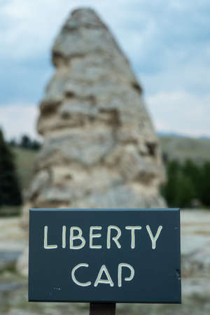 Liberty Cap Geyser and Sign in the Mammoth Hot Spring area of Yellowstoneの写真素材