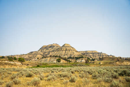 Badlands Formation Rises Out Of Grassy Prairie in Theodore Roosevelt National Parkの写真素材