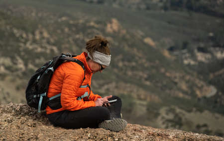 Female Hiker Takes a Break to Check Email