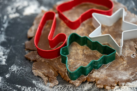 Assortment of Holiday Cookie Cutters Pressed Into Dough on floured surfaceの写真素材