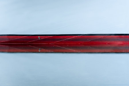 Reflecting On Two Medicine Lake with red stripe on bottom of boatの写真素材