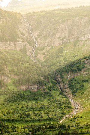 Shafts of Late Day Light Shine Through Logan Pass Into Valley Below in Glacier National Parkの写真素材