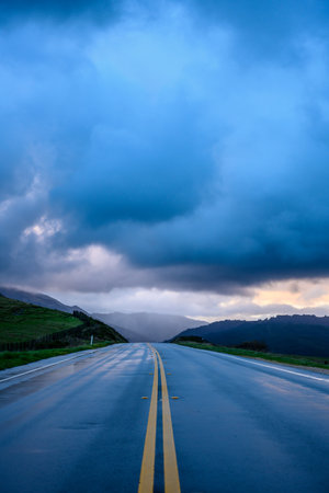 Rainy Road Glows Under Morning Sky on Big Sur coastの写真素材