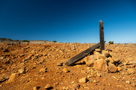 Old Fence Post Held Up By Stacked Orange Rocks in Channel Islands National Parkの写真素材