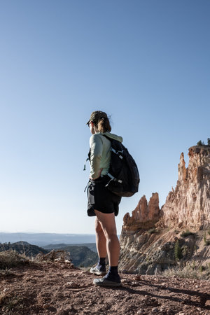 Woman Hiker Stands at Edge of Rim Trail in Bryce Canyon National Park
