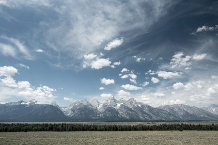 Muted Colors of Wispy Clouds Over Grand Teton Range in summerの写真素材