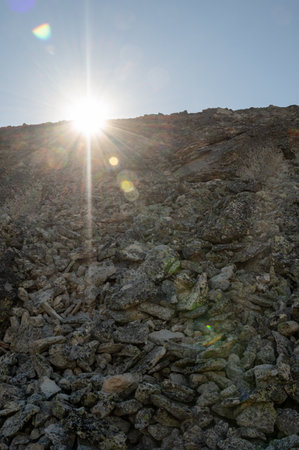 Sunburst Creeps Over The Rocky Summit Of Mt Holmes in Yellowstoneの写真素材