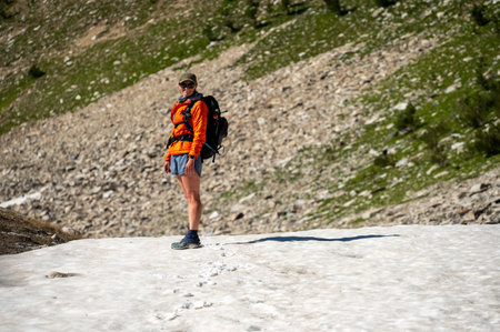 Woman Stands on Snow Bank Below Mount Holmes in Yellowstoneの写真素材