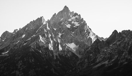 Evening Light Dapples The Cliffs Of Grand Teton at sunsetの写真素材