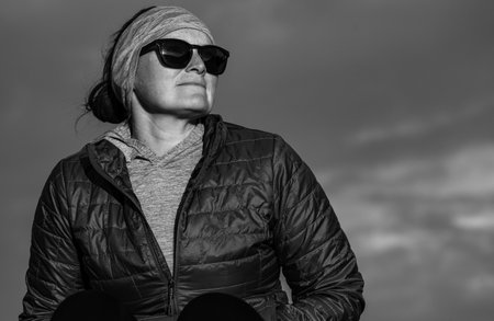 Woman Looks Out At Sunset In Black and White with copy space