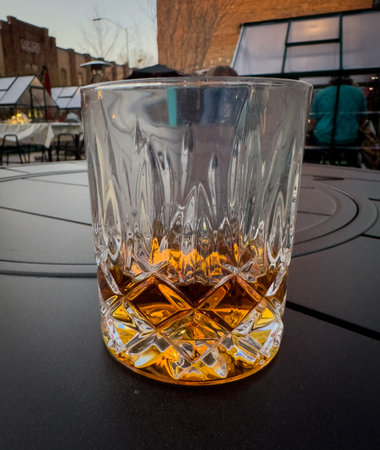 Glass of Sipping Bourbon on Outdoor Tableの写真素材