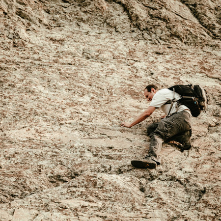 Man Climbs On Rock Face over Lake Haiyaha in Rocky Mountain National Parkの写真素材