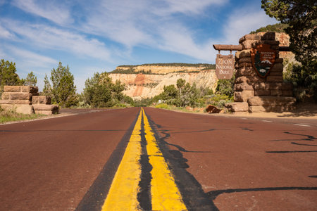 Zion National Park, United States: June 22, 2023: Yellow Stripe on Red Asphalt Heading into Zion National Parkの写真素材