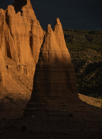Small Formation Catches Morning Sunlight With Needle Mountain Lit In The Distance in Capitol Reef National Parkの写真素材