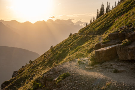 Bright Orange Sun Warms A Turn On The Highline Trail in Glacier National Parkの写真素材
