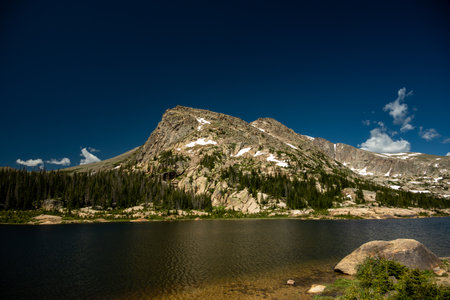 Dark Blue Sky And Mountains Over Lawn Lake In Rocky Mountain National Parkの写真素材