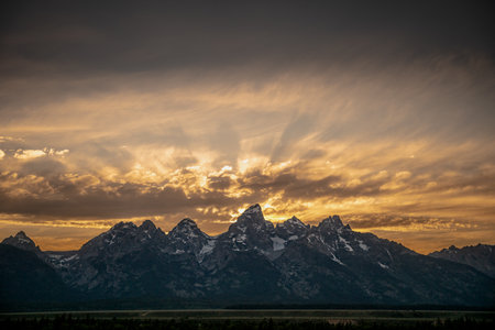 Sun Rays Burst From Behind The Mountains In Grand Teton National Parkの写真素材
