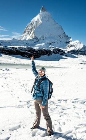 Woman Standing In Snow And Pointing At The Matterhorn in the early winter season