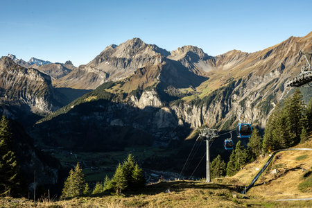 Blue Gondola Cars Pulled Up The Hill to Oeschinen Lake Area In The Swiss Alps in Autumnの写真素材