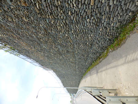 Wall of stones under the grid - gabionの写真素材