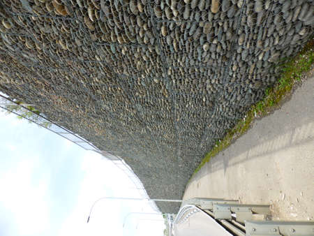 Wall of stones under the grid - gabionの写真素材