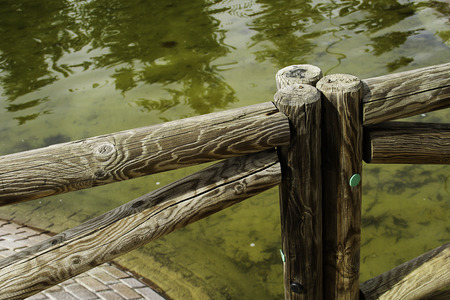 picket fence of wood  close to the green lake