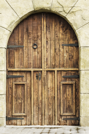 rustic and wooden entrance door on stone facadeの写真素材