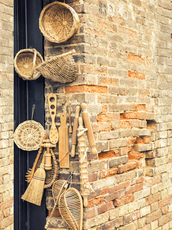wooden handicraft. Traditional utensils made with wood and wicker hung on a wallの写真素材