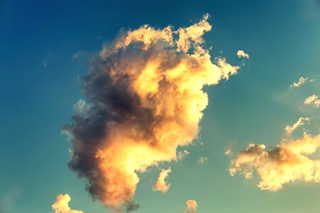 illuminated cloud wit warm orange color on the blue sky