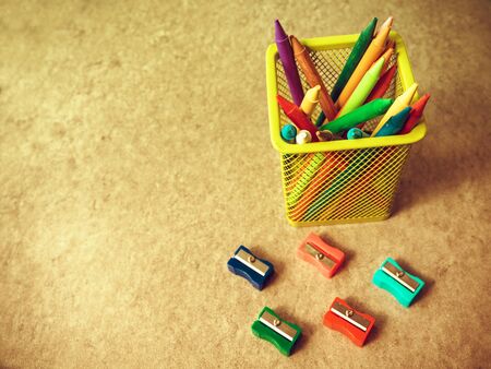 background of colored pencils to draw inside a yellow container surrounded by pencil sharpenersの写真素材