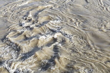top view of raging waters of a river overflowed by torrential rains