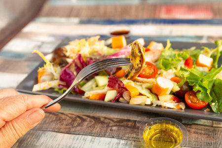 view of mussel on a fork and mixed seafood saladの写真素材
