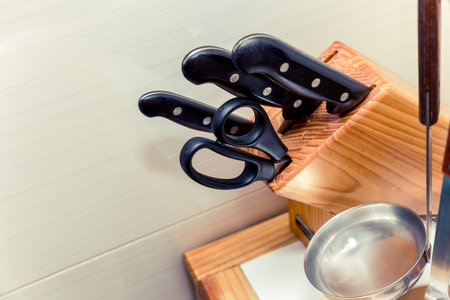 close up of knives and scissors on wooden blockの写真素材