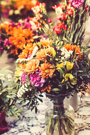 spring flowers bouquet in a glass vase on the shelf outdoorsの写真素材