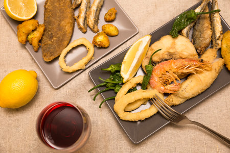 top view of dishes with golden fried fish and wineの写真素材