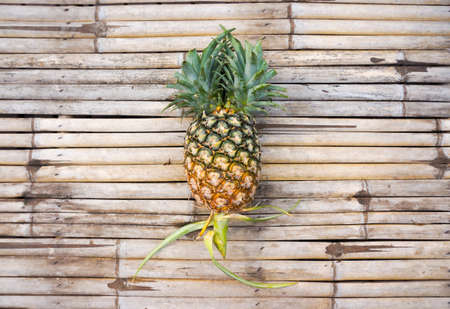 A pineapple on bamboo backgroundの写真素材