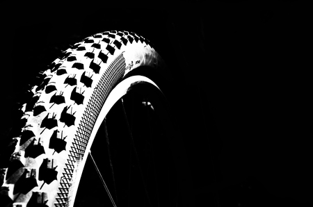Bicycle wheel on a black background. Leaflet, advertisement, banner. Place for text