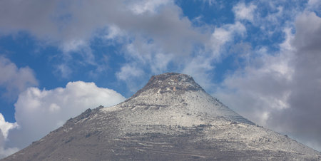 Mountain peak against blue sky with clouds. Panoramic view.