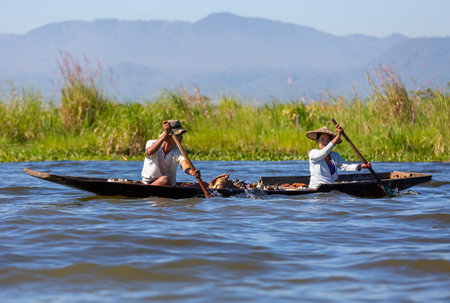 Unidentified people rowing a boat.の写真素材