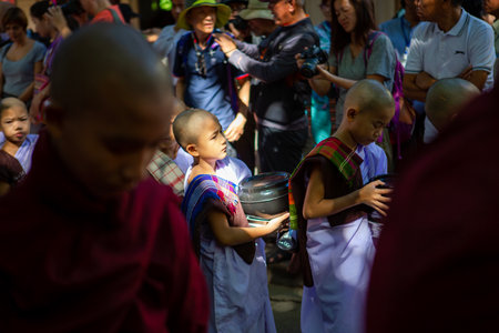 Unidentified buddhist monk giving alms to a monk in Bangkok, Thailand.の写真素材